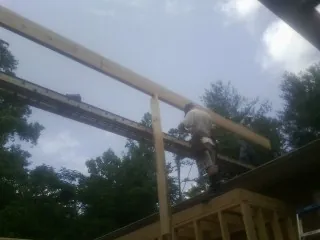 Carpenter setting a ridge beam over a new addition frame — Ice Dam Removal by Roofing Brothers in Washtucna