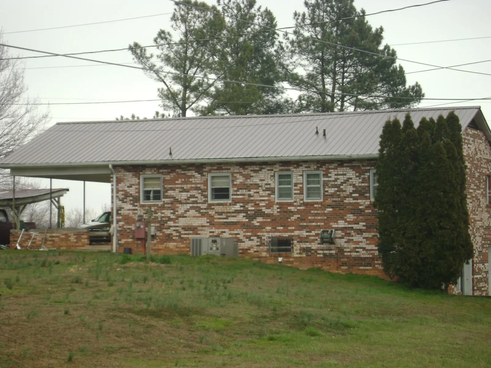 Gray metal roof on a brick split level home with a carport in Washtucna
