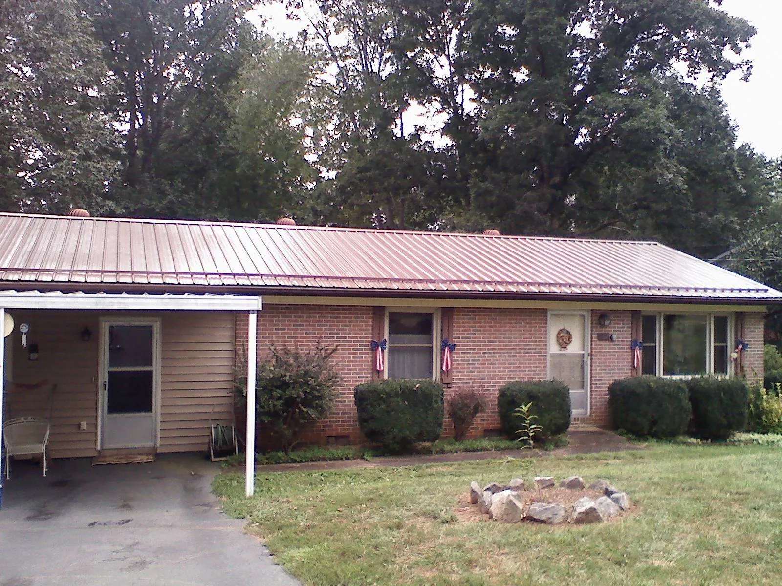 Bronze metal roof and carport on a brick ranch home — Roof Repair work by our crew in Washtucna