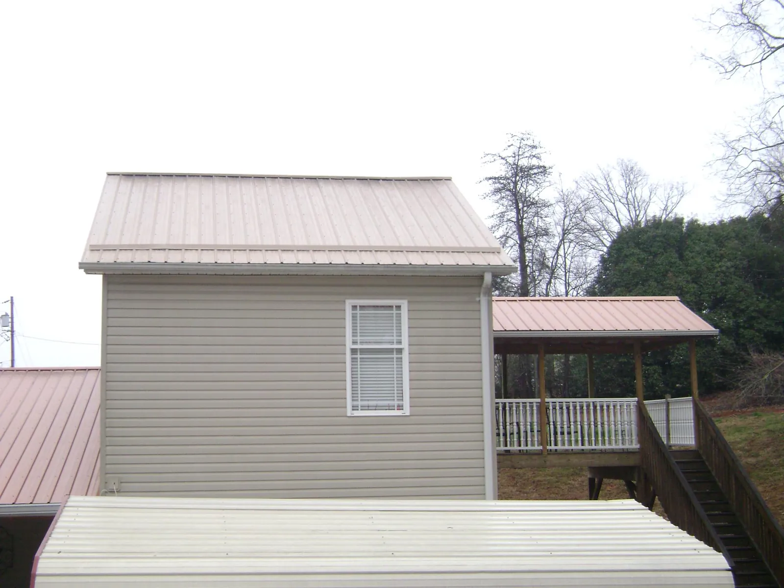 Tan metal roofs on a two story addition and attached porch, from a Roof Replacement job in Washtucna